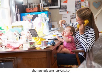 Mother With Daughter Running Small Business From Home Office