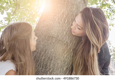 Mother And Daughter Are Rushing Around A Tree