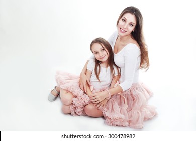 Mother And Daughter In Same Outfits Posing On Studio Hugging