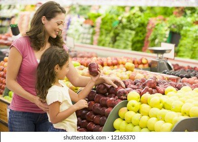 Mother And Daughter Shopping For Fresh Produce In Supermarket [approx. 7 Years Old]