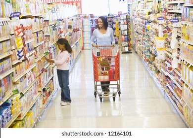 Mother And Daughter Shopping For Groceries In Supermarket