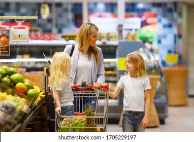 Mother And Daughter Shopping For Groceries In Supermarket