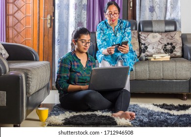 mother and daughter shopping online together using credit card with laptop and mobile
