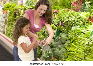 Mother And Daughter Shopping For Produce In Supermarket