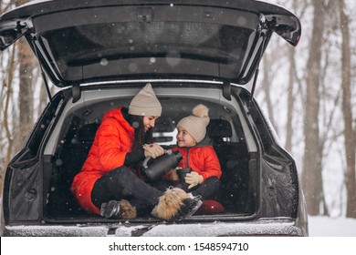 Mother With Daughter Sitting In Car In Winter