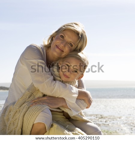 A mother and daughter sitting on a beach