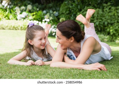 Mother And Daughter Smiling At Each Other Outside In The Garden