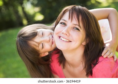 Mother and daughter smiling outdoor.