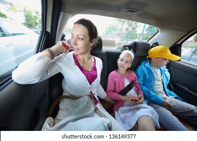 Mother, Daughter And Son In The Back Seat Of A Car