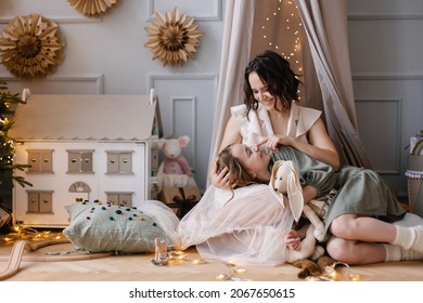 Mother and daughter spend time together. Mother's love. Teenager girl children's room. Hugs and care. mom and 10-year-old girl. Christmas Eve. Decorated room stylish interior cosiness. Happy New Year