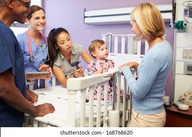 Mother And Daughter With Staff In Pediatric Ward Of Hospital