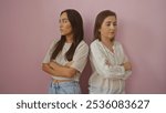 Mother and daughter standing back to back with arms crossed against a pink background, showcasing family tension and strong emotions between two women