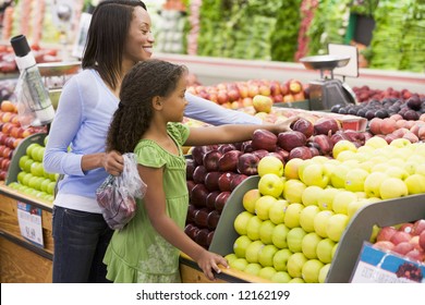 Mother And Daughter In Supermarket Produce Section