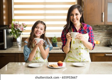 Mother and daughter taking a break from cooking together and drinking a cup of coffee - Shutterstock ID 655953667
