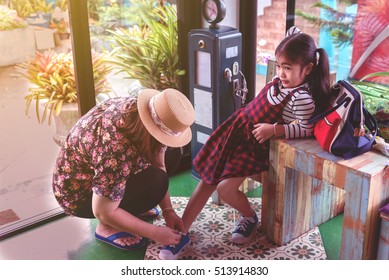 Mother Daughter To Tie Their Shoes In The Cafe.