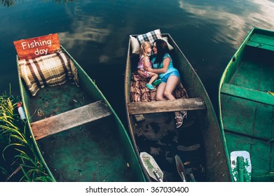 Mother And Daughter Together In A Boat Ride On The Lake.