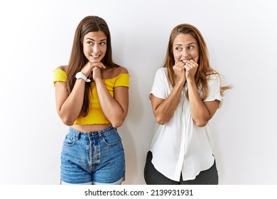 Mother And Daughter Together Standing Together Over Isolated Background Laughing Nervous And Excited With Hands On Chin Looking To The Side 