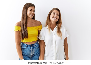 Mother And Daughter Together Standing Together Over Isolated Background Looking Away To Side With Smile On Face, Natural Expression. Laughing Confident. 