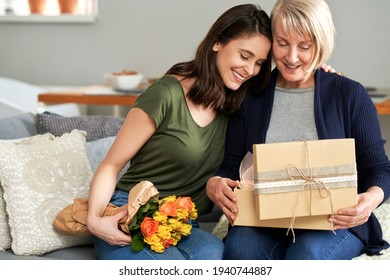 Mutter und Tochter packen zusammen ein Geschenk aus                               