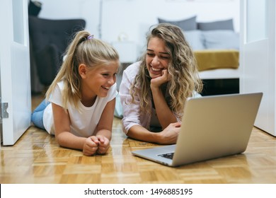 Mother And Daughter Using Laptop Computer At Home