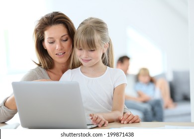 Mother And Daughter Using Laptop Computer At Home