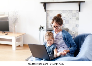 Mother And Daughter Using Laptop At Home Office. Woman And Child In Virtual School Class. Freelancer Workplace For Female Business, Working Mom, Homeschooling, Online Education. Technology Lifestyle