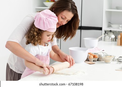 Mother and daughter using a rolling pin together in the kitchen - Powered by Shutterstock