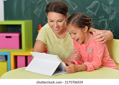 mother and daughter using tablet computer