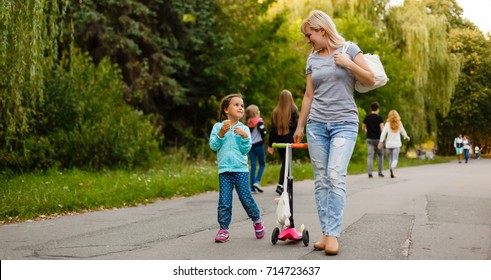 Mother And Daughter Walking Along Path