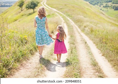 Mother And Daughter Walking Holding Their Hands