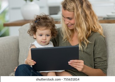 Mother And Daughter Watching Tv On Tablet