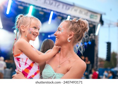 Mother With Daughter Wearing Glitter Having Fun At Outdoor Summer Music Festival - Powered by Shutterstock