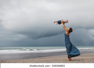 Mother And Daughter Wearing Matching Clothes In Dark Blue Colours Spending Fun Time Outside On The Beach During Luxury Family Vacation