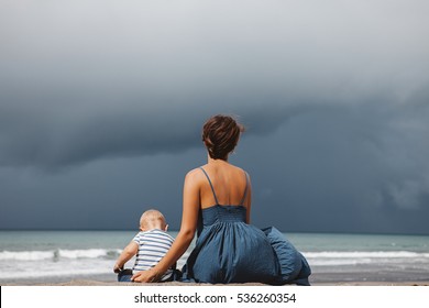 Mother And Daughter Wearing Matching Clothes In Dark Blue Colours Spending Fun Time Outside On The Beach During Luxury Family Vacation