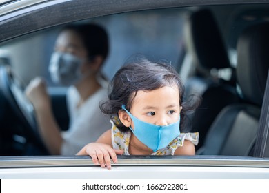 Mother And Daughter Wearing Medical Disposable Face Mask To Prevent Pollution, Flu And Convid-19 While Parking A Car.