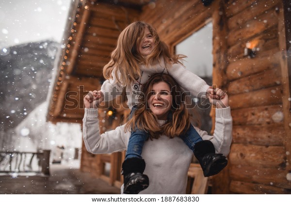 Mother and daughter in\
winter chalet