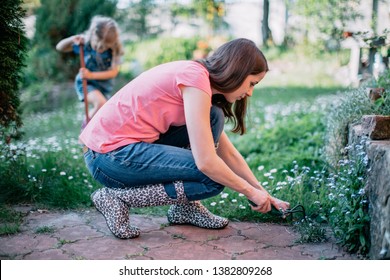 Mother and daughter working in the garden with gardening equipment