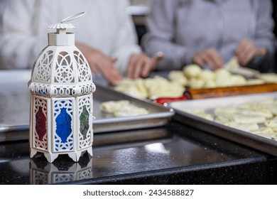 mother and daughter are working together preparing pastries for iftar in ramadan with lantern in front, ramadan pattern