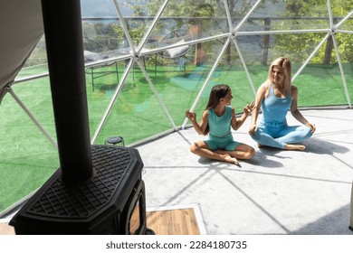 mother and daughter yoga in glamping dome tent domestic