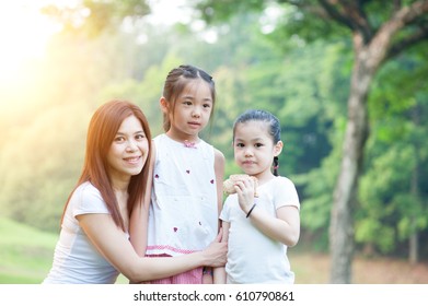 Mother And Daughters Enjoying In The Park, Asian Family Outdoor Lifestyle, Morning With Sun Flare.