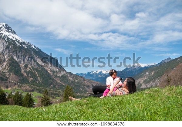 Mother day bonding and Single mom
concept. Mother is holding and playing baby girl on the mountain in
sunny day. Family time with mom and daughter in
summer