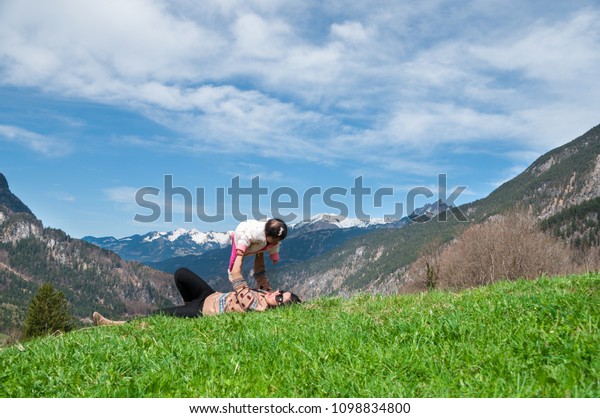 Mother day bonding and Single mom\
concept. Mother is holding and playing baby girl on the mountain in\
sunny day. Family time with mom and daughter in\
summer