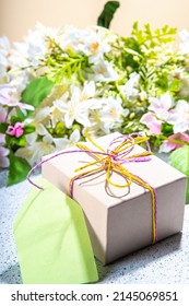 Mother Day Greeting Card Background With Present And Flowers. Gift Box With Festive Ribbon, Tag Love You Mom, Spring Bloom Flowering Branches Bouquet Flatlay Copy Space