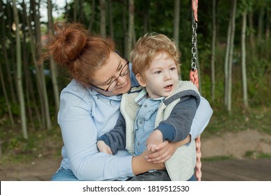 Mother and disabled son walk in the fresh air in a chair, medical mobile equipment
