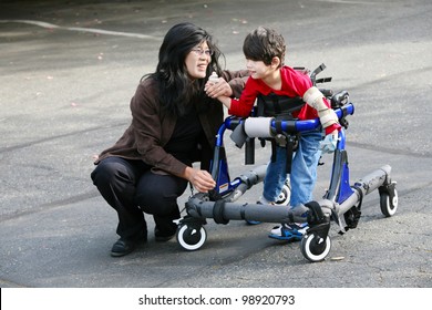 Mother with disabled son walking outdoors with walker, medical mobility equipment - Powered by Shutterstock