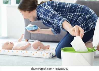 Mother Disposing Of Baby Wipe In Bin