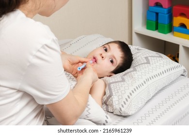 A Mother Or Doctor Gives A 4-year-old Child A Medicine For Fever Or Cough. Treatment Of Children From Bronchitis, Pneumonia, Antibiotics In Pediatrics.