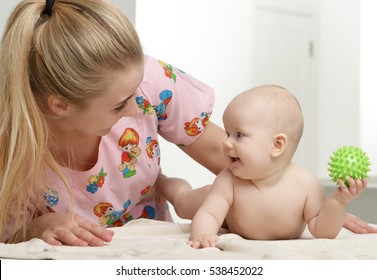 Mother Doctor Pediatrician Massage Therapist With Child Infant Baby Girl At Home. Health Care And Medicine Concept