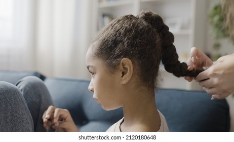 Mother doing daughter's hairstyle at home, preparing for school in the morning - Powered by Shutterstock