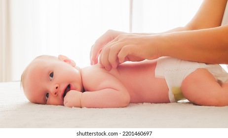 Mother Doing Massage On Her Healthy Infant Baby. Small Caucasian Newborn Laying On His Belly While His Mother Is Performing A Massage For His Small Back And Developing Muscles. 
